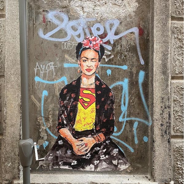 Graffiti von Frida Kahlo, die mit einem Auge zwinkert und ein T-Shirt mit Superman-Symbol trägt, als Symbolbild für den Workshop "Stärken leben – leben Stärken" in Berlin.
