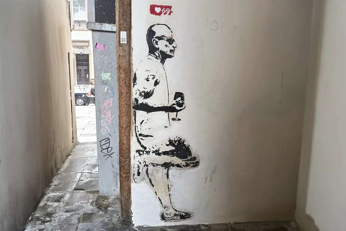 Graffiti eines Mannes, der mit angewinkeltem Bein an einer Wand lehnt, darüber 69 Insta Likes als Symbol für Resilienz stärken.